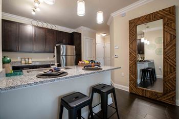 a kitchen with a counter top with bar stools